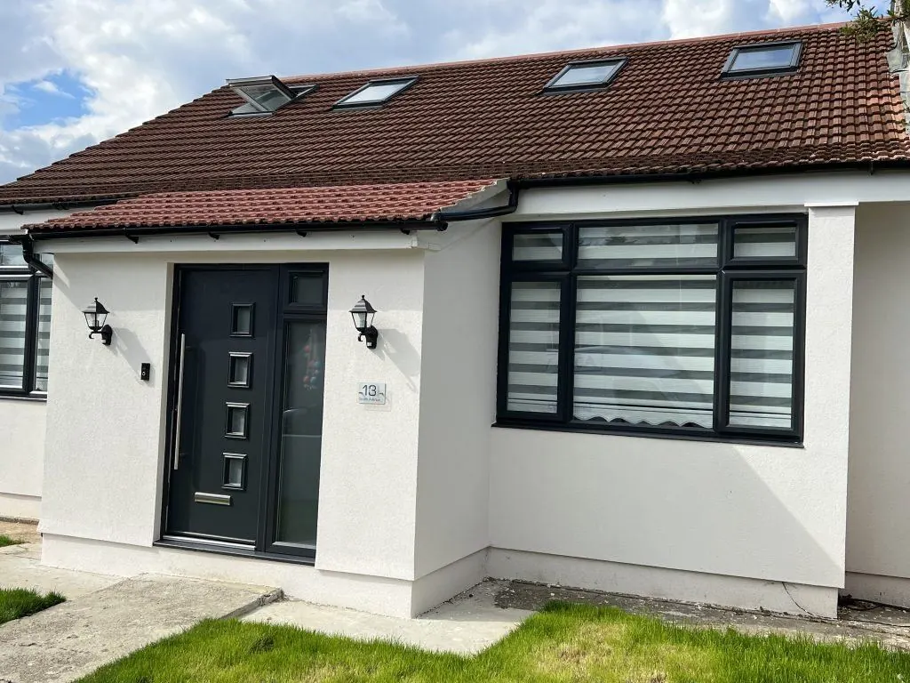 Anthracite composite door and matching windows on a rendered house