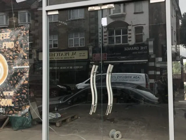 Frameless glass shopfront with steel handles