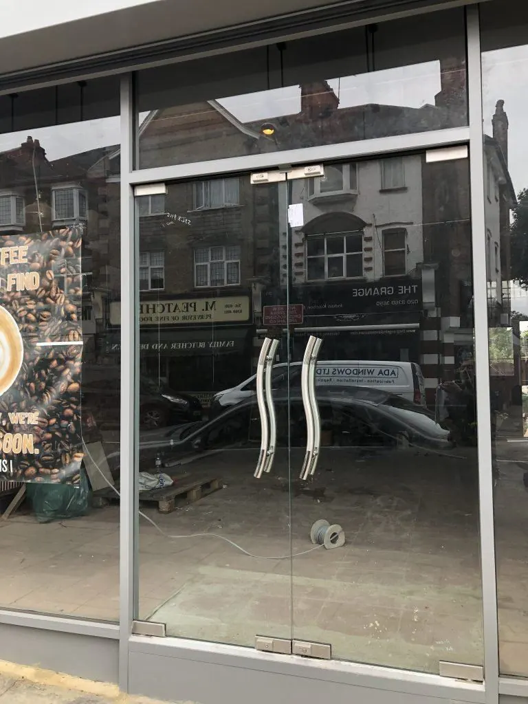 Frameless glass shopfront with steel handles